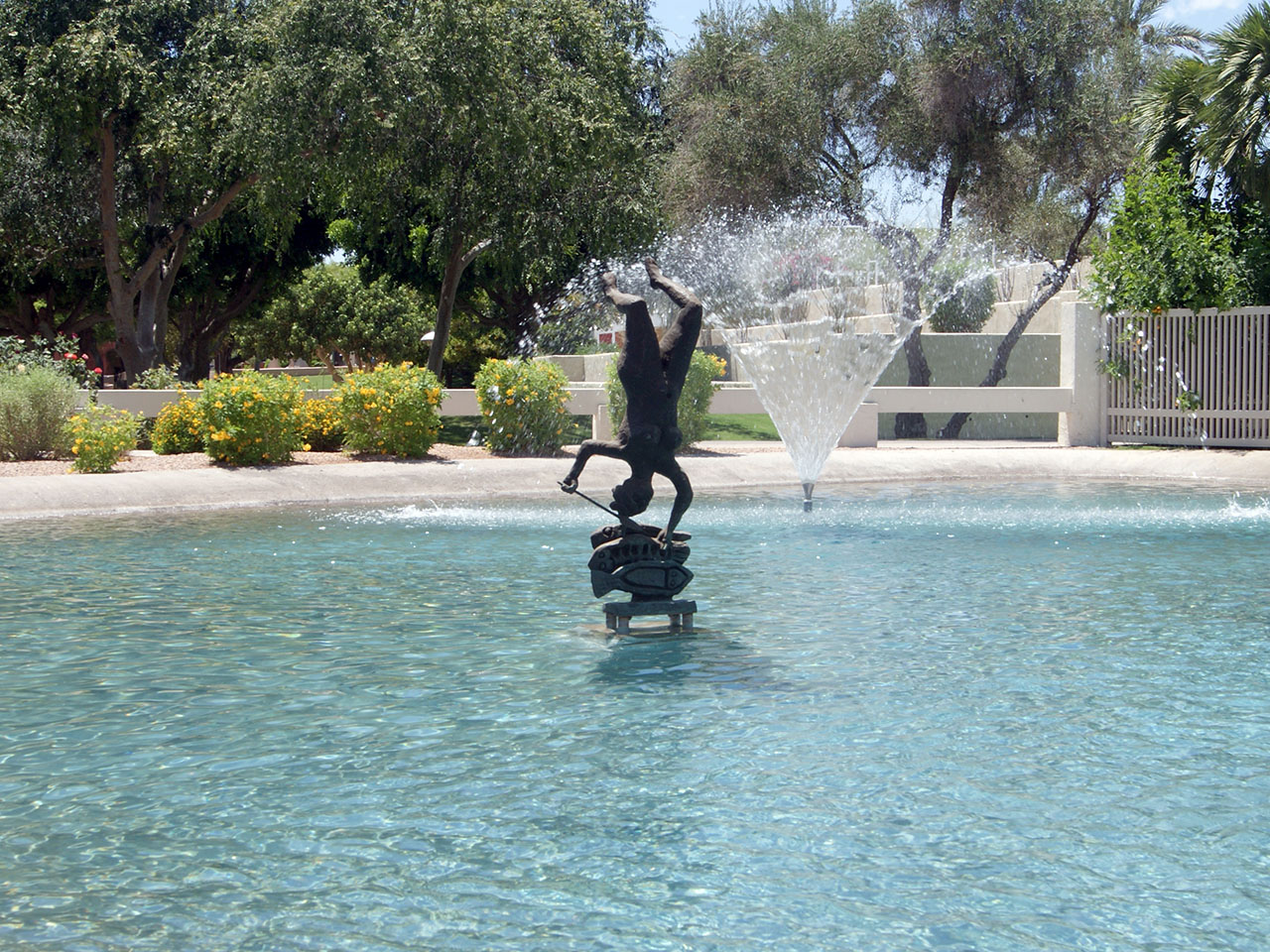 woman and fish sculpture in a pond